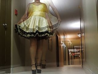 sissy 드레스와 섹시한 발 뒤꿈치에서 호텔 복도의 시시 빛
